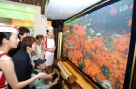KIECO 2005에서 선보인 71인치 금장 PDP와 세계 최초 골드 홈씨어터(모델명 : LH-C643)를 관람객들이 유심히 보고 있다.