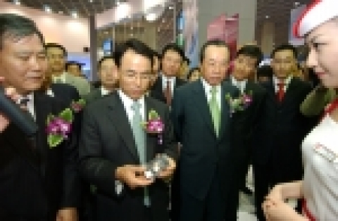 진대제 정보통신부 장관(사진 중앙)이 LG전자 전시관을 찾아 위성DMB폰(LG-SB120)을 손에 들고 유심히 보고 있다. 진대제 장관 오른쪽은 김재철 무역협회장.