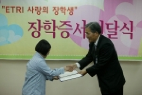 ETRI 임주환 원장이 2005년도 사랑의 장학생으로 선발된 학생에게 장학증서를 전달하고 있다.