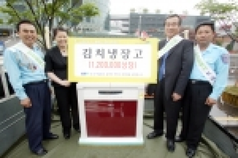 KTF 컨버전스 사업실장 이경수 상무가 5월 첫째주 당첨된 고객에게 김치냉장고 경품을 증정하고 있다.