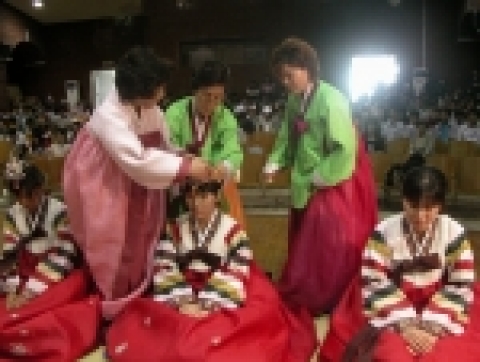 삼가례 축사가 끝난 후 주례자가 남학생에게는 冠을, 여학생에게는 족두리를 씌워주고 있는 모습.