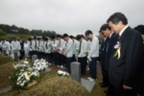 고 윤상원 열사의 묘비 앞에 학교 후배들과 함께 묵념하고 있는 손학규지사. 사레지에고 학생들이 광주 시내 6개 고등학교 학생들이 접은 '희망의 종이학'을 들고 있다.