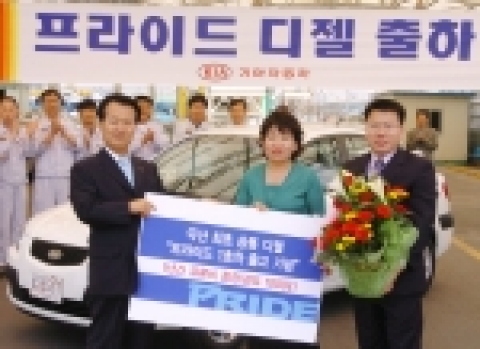 기아차는 23일 소하리공장 출하장에서 1호차 주인공인 신관철씨(51세, 중학교교사)의 부인인 이현상씨(사진 가운데)(42세, 주부)에게 국내 첫 디젤승용차인 프라이드 디젤모델과 함께 유류 1천리터 상품권을 전달하는 기념식을 가졌다. (사진 왼쪽 인물 : 이광우 국내영업본부장)