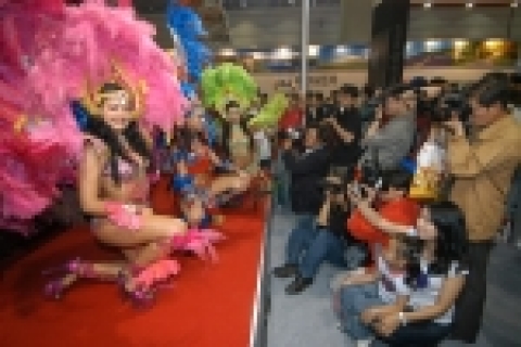 5월 26일 진행된 서울 국제 사진 영상 기자재전에서 소비자들이 LG 상사 캐논 부스 내 브라질 삼바 댄서를 캐논 카메라로 찍어보고 있다.