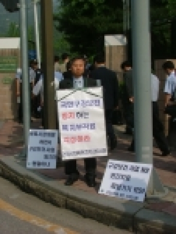 과천 정부종합청사 앞에서 1인시위를 하고 있는 한영철 회원-건강사회를 위한 치과의사회의 전 회장이고, 대한치과의사협회에서 치무이사를 했던 한영철 원장은 이 1인시위를 통해서 무엇을 말하고자 하는 것일까? 한원장이 목에 건 팻말에는 이렇게 쓰여있다. &#039;국민구강보건방치하는 보건복지부 관료 각성하라&#039; &#039;6월9일 오늘은 치아의 날&#039; &#039;건강한 치아는 국가의 책임이다&#039;
