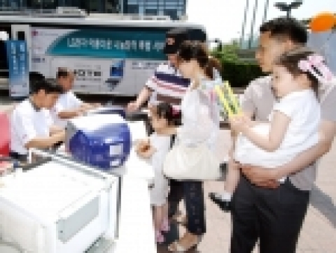 '움직이는 CYON 센터’의 서비스 엔지니어들이 고객이 가져온 고장난 가전제품을 수리하고 있다