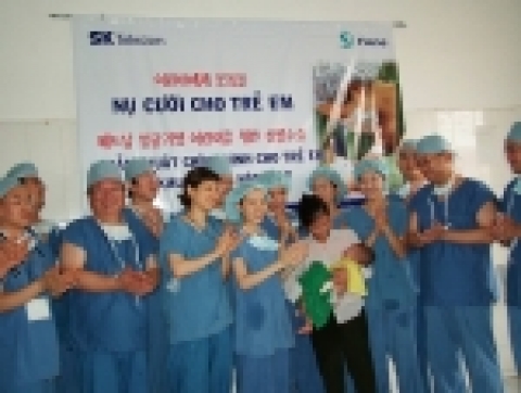 2000번째 수술을 무사히 마친 도 민 도(생후 6개월)와 어머니 친 티 방(31세)에게 의료진들이 축하의 박수를 보내는 모습