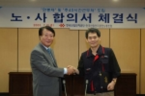 한국산업단지공단 김칠두 이사장(사진 왼쪽)과 전효균 노동조합 위원장이 ‘전 직원 연봉제 도입’ 합의서를 체결하고 서로 악수를 나누고 있다.