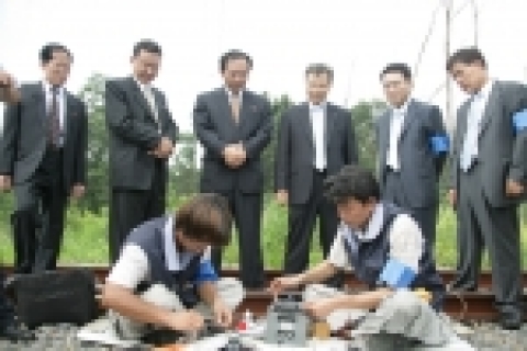 문산-개성을 종단하는 철도와 남북군사분계선이 만나는 지점에서 남북 광케이블 연결식에서 KT직원들이 케이블을 연결작업을 하고 있다. 사진 뒷줄 우측으로 부터: KT남북협력팀 김태환부장, KT남북협력팀 김병주 상무, KT 사업협력실 맹수호 실장, 조선체신회사 김인철 부이사장 , 북측 관계자 등