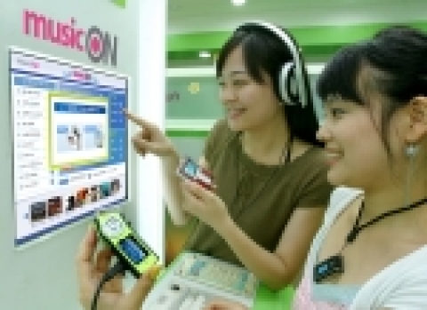 LG텔레콤(사장 南 鏞 / www.lgtelecom.com)과 세계적인 휴대형 멀티미디어 업체인 레인콤(사장 楊德準 / www.reigncom.com)은 최근 음악사업을 위해 상호 협력키로 하는 업무 제휴를 체결했다고 28일 밝혔다. 사진은 LG텔레콤 직원이 레인콤의 아이리버로 Phone&Fun 매장에서 뮤직온을 통해 음악파일 다운로드를 테스트하고 있는 모습.