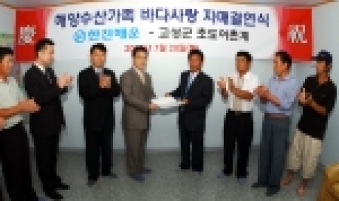 한진해운 유한일 부장이 정철규 초도면 어촌계장에게 자매결연 증서를 전달하고 있다.