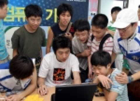 T1의 임요환 선수가 '별'의 학생들이 선물한 T셔츠를 입고 스타크래프트 게임을 시연하는 모습