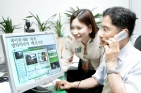 데이콤 김윤열 전화사업부 상무(사진 右)가 NHN과의 제휴를 통해 제공될 멀티미디어 메신저폰을 이용하고 있다. 