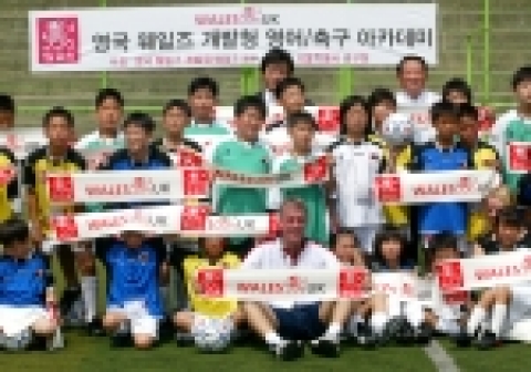 영국 웨일즈 개발청 주관 영어 / 축구 아카데미에 참석한 전직 프리미어 리그 선수 제임스 피어슨(첫 줄 가운데)과 성낙합 중구청장(뒷줄 오른쪽), 그리고 웨일즈 개발청 한국사부소장 황재필 소장(뒷 줄 가운데)이 참석 어린이들과 함께 웨일즈 응원 머플러를 펼쳐 보이고 있다.