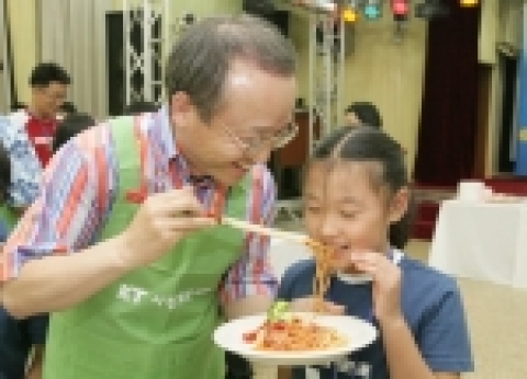시식 : 남중수 사장이 직접 만든 스파게티를 어린이에게 먹여주고 있다.