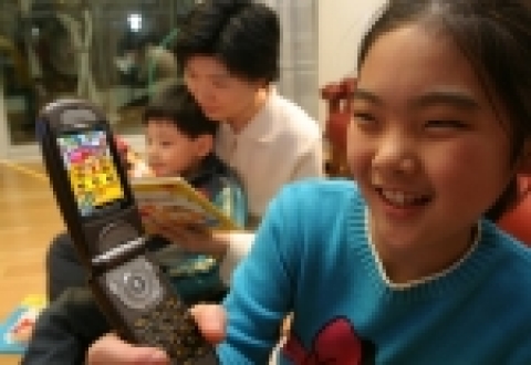 어린이가 키즈랜드에서 다운로드 받은 어린이 게임을 휴대폰으로 즐기고 있는 모습.