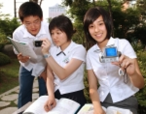 남녀 고등학생들이 야외에서 TU 교육방송을 보고 있는 모습