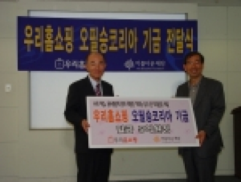 우리홈쇼핑 정대종 사장(왼쪽)이 아름다운 재단 박원순 상임이사(오른쪽)에게 오필승코리아 기금 5억원을 전달하고 있다.