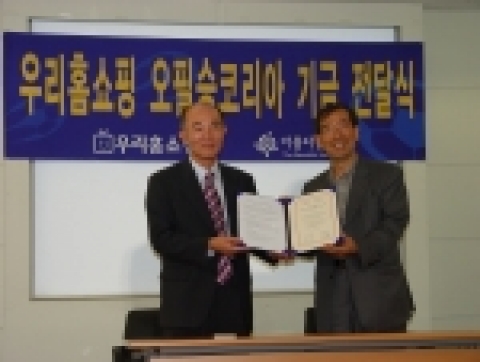 우리홈쇼핑 정대종 사장(왼쪽)이 아름다운 재단 박원순 상임이사(오른쪽)에게 오필승코리아 기금 약정서를 전달하고 있다.
