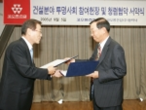 코오롱건설 민경조 사장(오른쪽)과 협력사 대표 대유산업 정병찬 사장(왼쪽)이 '건설 분야 투명사회 참여헌장 및 청렴협약 서약서’에 서명후 서로 교환하고 있다.