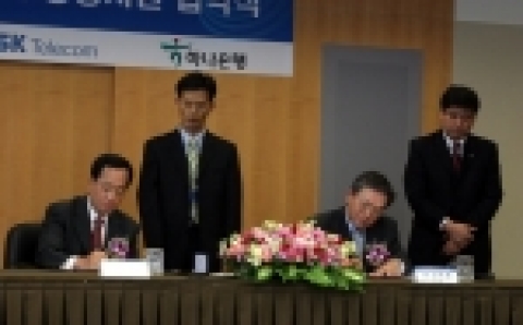 김신배 SK텔레콤 사장(左), 김종열 하나은행장(右)이 협약서에 서명을 하고 있다.
