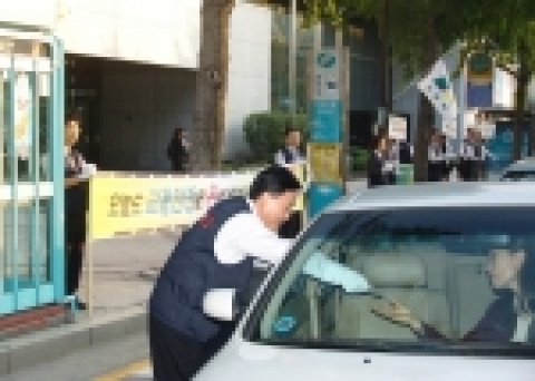 정경득 은행장을 포함한 경남은행 봉사단이 교통안전캠페인에 펼치며 운전자들에게 안전 운전을 당부하는 스티커를 나눠 주고 있다.
