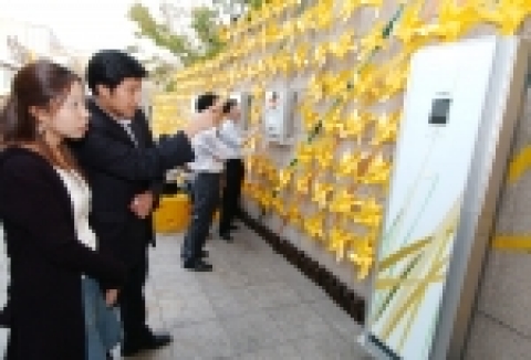 예술의 전당 한가람 미술관을 찾은 관람객들이 미술관 입구 외벽에 봉국환 디자이너가 바람개비와 갈대, 5대의 휘센을 이용해 가을 이미지를 형상화한 퍼포먼스를 감상하고 있다.