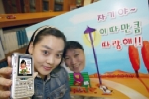 KTF 직원이 자신의 얼굴로 만든‘포토 아바타’서비스를 소개하고 있다.