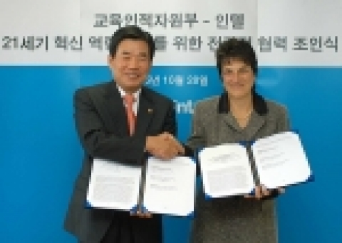 교육인적자원부의 김진표 장관과 인텔의 브렌다 무실리 교육 총괄이 양해각서를 교환하고 악수하는 장면