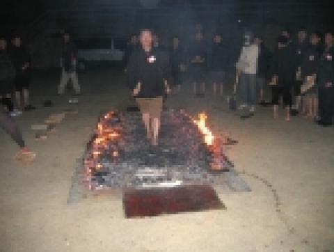 직원연수에 참가한 한 교육생이 시뻘겋게 달아오른 숯불판 위를 맨 발로 걷고있다.