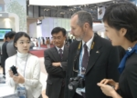 15일 부산 벡스코 전시장에서 개막한 'APEC 2005 IT전시회'의 삼성전자 부스에 외국 통신업계 관계자가 방문해 삼성전자가 세계 최초로 개발한 PDA 타입의 와이브로 단말기를 살펴보고 있다.