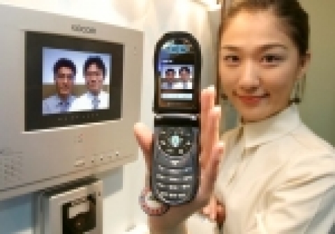 한전KDN 전시관에서 한 직원이 휴대폰을 이용한 원격 모바일솔루션 서비스를 시연하는 장면