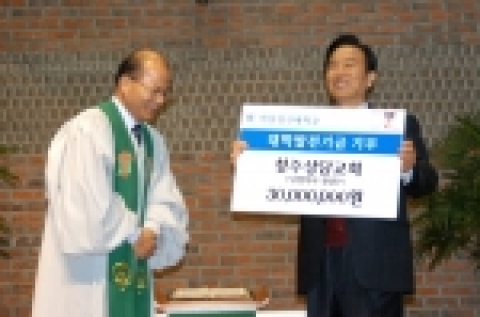 11월 22일 청주상당교회 정삼수 목사(왼쪽)으로부터 후원금을 전달받은 정장복 총장이 환하게 웃고 있다.