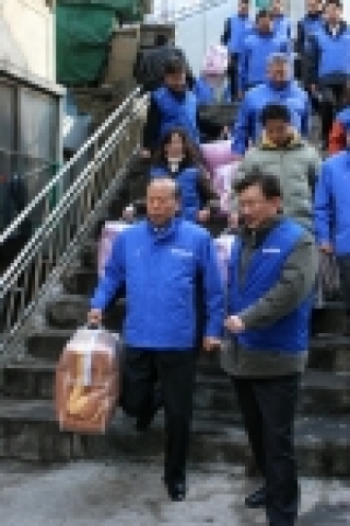 이불을 들고 쪽방으로 향하는 허태학 사장(왼쪽)