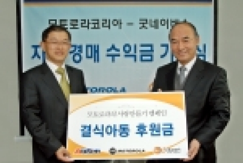 모토로라코리아 길현창 대표이사가 사회복지전문단체 굿네이버스 이일하회장에게 자선경매 판매금 전액을 기탁하고 있다.