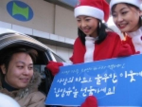 서울 종로구 현대오일뱅크 한 주유소에서 전문 홍보도우미들이 방문 고객들에게 불우이웃을 추천할 수 있는 '사랑의 카드'를 배포하고 프로그램을 설명하고 있는 모습임.