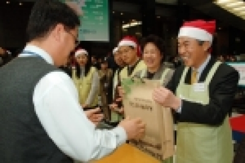 23일 포스코센터에서 열린 '포스코 나눔마당' 행사에서 포스코 이구택 회장과 부인 이정란 여사가 물품을 판매하고 있다.