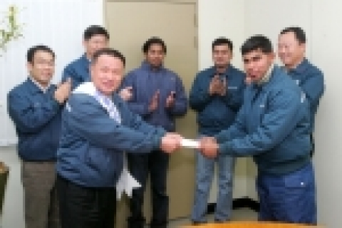 스리랑카인 브디카 씨(오른쪽)가 모은 성금을 회사측에 전달하는 장면