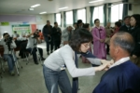 상명대 사진학과 학생들이 노인장수사진 무료촬영행사장인 충북청원군 행사장에서 군내 노인들에게 영정사진을 찍어주며 옷매무새를 다들어주고 있다.