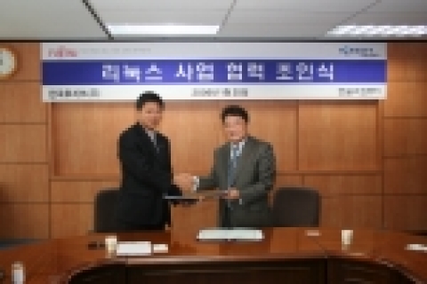 한국후지쯔 김병원 대표(왼쪽)과 한글과컴퓨터 백종진 대표(오른쪽)이 양해각서를 교환하고 서로 악수하는 장면
