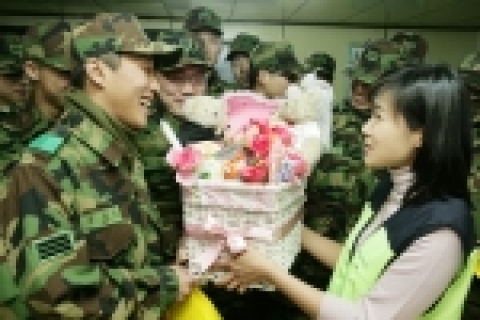 KT의 여사원 봉사단원들이 발렌타인데이를 맞아 장병들에게 쵸콜렛과 전화카드를 전달하고 있다.