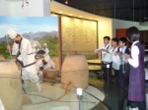 진천 종박물관을 방문한 학생들이 종을 만드는 과정을 전시한 곳에서 흥미로운 모습으로 관찰하고 있다.