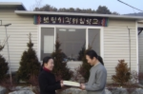 교육장을 대신해 도서관장이 기증증서 전달하는 장면