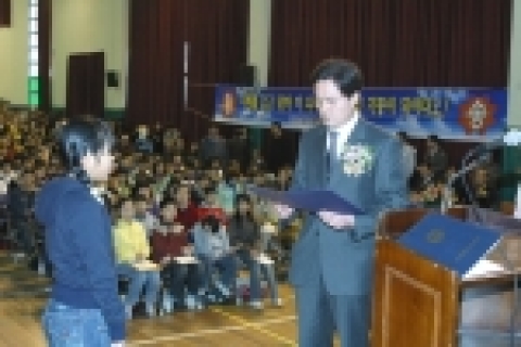 광주과기원  조영욱 예산기금팀장이 15일 비아초등학교 졸업식에 참석해 오진아 어린이에게 광주과학기술원장상과 장학금을 전달하고 있다.