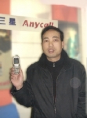 저수지에 빠뜨린 휴대폰을 되찾은 저우지엔펑이 나중에 찾은 휴대폰을 들고 포즈를 취하는 모습