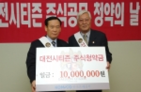 조폐공사 강성천 기획이사(왼쪽)가 대전시티즌 강효섭 사장(왼쪽)에게 주식청약금을 전달하고 함께 포즈를 취하고 있다.