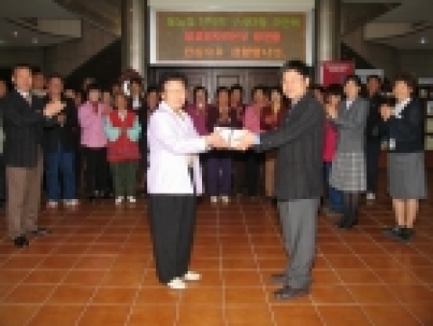 영광원전 이광석 홍보기술과장이 지역주민초청홍보 1,000번째 방문객에게 기념품을 증정하고 있다.