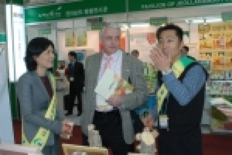 충남농업테크노파크의 후원으로 서울국제식품전에 참가한 한 농기업 대표가 외국 바이어에게 상품을 소개하고 있다.