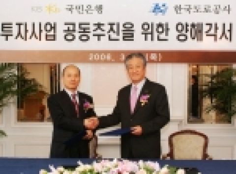 KB국민은행 오용국 기업금융그룹 부행장(사진 오른쪽)과 한국도로공사 정해수 부사장이 민간투자사업 공동추진을 위한 양해각서 체결 후 악수를 하고 있다