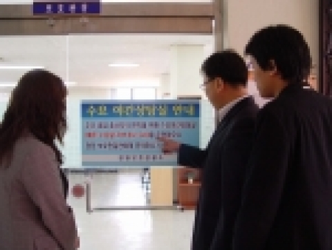 야간 상담실 운영에 관한 안내문을 보고 있는 보호관찰대상자